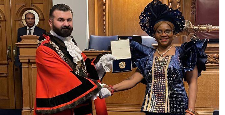 New Mayor handing previous Mayor a medal for her services