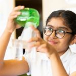 Big Idea Event - scientific solutions for society - girl looking at glass jar with green liguid in it
