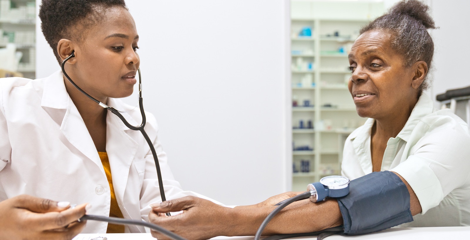 Female doctor measuring blood pressure of senior women - istock photo