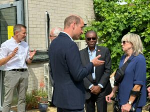 Prince William speaks with a woman at the launch of Homeward at Mosaic Clubhouse