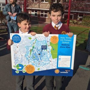 two boys hold up Trinity School clean air walking maps