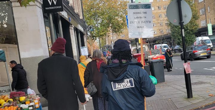 street pastor carrying Faiths Together in Lambeth peace walk banner on Streatham High street