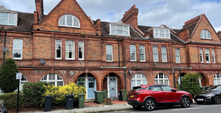 brick terrace houses with a car parked outside