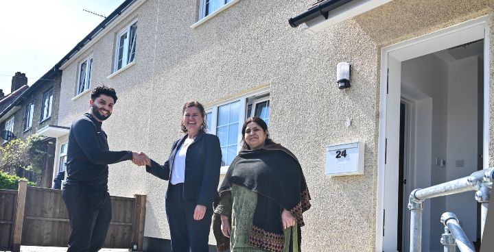 Young Asian mother with his mother stand with woman outside new house. Smiling at camera