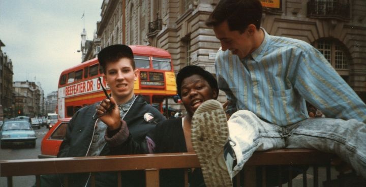 Share your pride - 1990s photo of 3 young people with red double decker London bus in background - photo by Clare Truscott