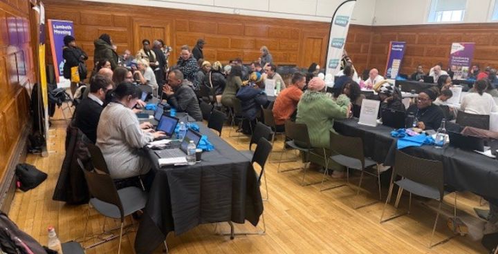 Group of people sitting at long at tables. Men and women of different heritages but you can't see individuals close up.
