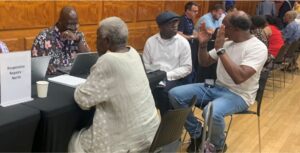 A lady and 2 gentlemen discuss matters with a member of the North area repairs team across a table.